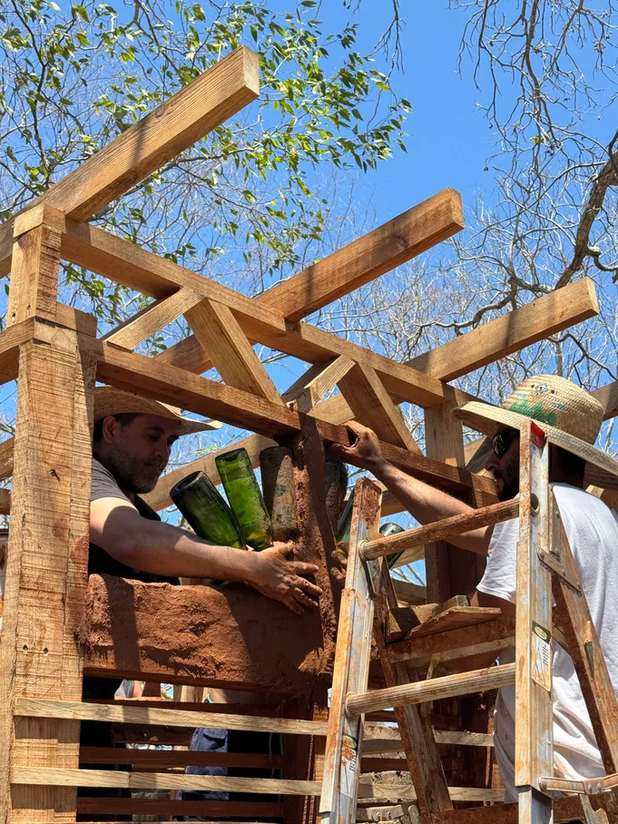 Equipo instalando barro entre una estructura de madera